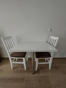 a white table and two chairs sitting next to it at Ekskluziv apartmani in Paraćin