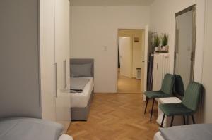 ein Schlafzimmer mit einem Bett und zwei grünen Stühlen in der Unterkunft New City Center Stays 2 in München