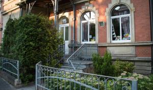 ein Backsteinhaus mit einem Zaun davor in der Unterkunft tRAUMhaus in Erfurt