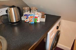 a kitchen counter top with a coffee maker and milk at Olive Tree 2 bed Apartment - STAYSEEKERS in Salisbury