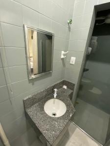 a bathroom with a sink and a mirror at Eldorado Inn in Feira de Santana