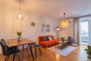 sala de estar con sofá naranja y mesa en City Garden Apartment en Poreč