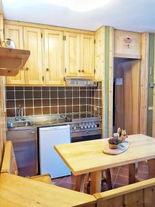 uma cozinha com armários de madeira e uma mesa de madeira em Bormio Little house em Bormio