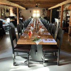 a long wooden table with chairs around it at Kvebergsøya Gard in Grimsbu