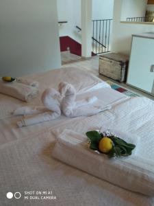 ein Bett mit Handtüchern darüber und Obst darauf in der Unterkunft Casa Vacanza CADORNA RESIDENCE in Tarvis