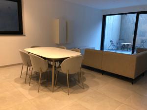 - une salle à manger avec une table, des chaises et un canapé dans l'établissement Garou, à Luxembourg