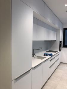 a kitchen with white cabinets and a sink at Garou in Luxembourg
