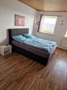 Posto letto in camera con pavimento in legno. di Ferien auf der Sönnenswarf a Ockholm