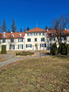 un gran edificio blanco con techo rojo en Apartma Vrtnica, Vila Golf, en Rogaška Slatina