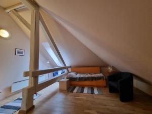 a attic bedroom with a bed and a staircase at Apartma Vrtnica, Vila Golf in Rogaška Slatina