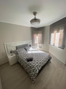 a bedroom with a bed with a black and white comforter at Precioso apartamento a 50 metros de la playa in Melilla