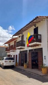 um carro estacionado em frente a um edifício com uma bandeira em Casona CHARA em Barichara