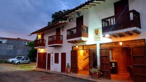 a building with balconies and a car parked in front of it at Casona CHARA in Barichara