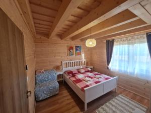 韦尔卡鲁穆尼卡Panorama Tatry Chalets的一间卧室，里面有一张床、一张桌子和一扇窗户