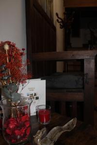a table with a vase with red flowers in it at EL REAL DE SIOTA in Castañares de Rioja
