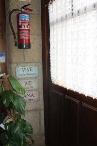 um hidrante pendurado numa parede ao lado de uma porta em EL REAL DE SIOTA em Castañares de Rioja