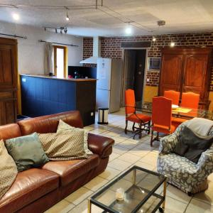 a living room with a couch and chairs and a kitchen at Le Val d'Andé in Andé