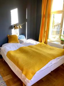 um quarto com uma cama com um cobertor amarelo em FärgLabbets Bed and Breakfast em Sunne