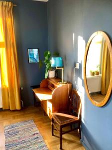 a room with a desk with a mirror and a chair at FärgLabbets Bed and Breakfast in Sunne