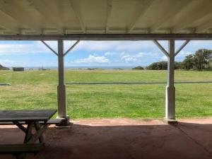 un pabellón con una mesa de picnic y un campo de hierba en Tillicum Beach Motel - Formerly Deane's Oceanfront Lodge, en Yachats