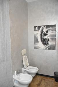 La salle de bains est pourvue de toilettes blanches et d'un lavabo. dans l'établissement Casa margot, à Riva Ligure