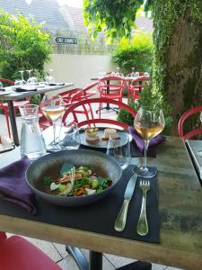 una mesa con un tazón de comida y copas de vino en Chez Jeannette, en Fixin