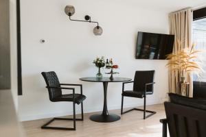 a dining room table with two chairs and a lamp at Appartement De Torenhoeve NIEUW in Burgh Haamstede