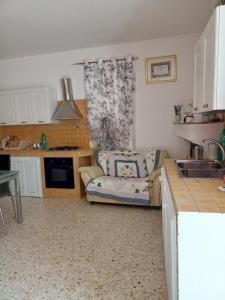 a living room with a couch and a kitchen at La casetta in Pomarico