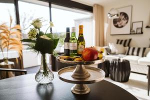 a table with bottles of wine and apples on it at Appartement De Torenhoeve NIEUW in Burgh Haamstede