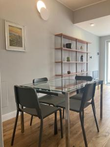 a dining room with a glass table and chairs at City Life Top apartment in Milan
