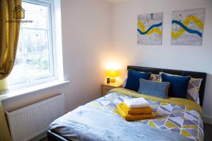 a bedroom with a bed with blue pillows and a window at Executive 2 Bed Flat in Stockton Heath by Amazing Spaces Relocations Ltd in Warrington