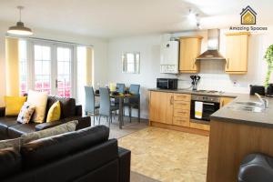 a kitchen and living room with a couch and a table at Executive 2 Bed Flat in Stockton Heath by Amazing Spaces Relocations Ltd in Warrington