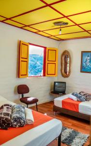 a room with two beds and a tv in it at Abuela Casa Hostal in Apía