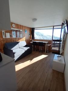 a living room with a couch and a table in a room at STUDIO DE LA BICHETTE in Besse-et-Saint-Anastaise