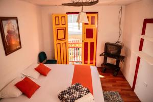 um quarto com uma cama e uma televisão em Abuela Casa Hostal em Apía