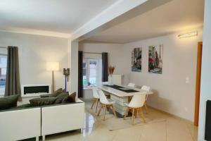 a living room with a couch and a table and chairs at Modern 3 bedroom apartment near Useldange castle in Useldange