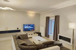 sala de estar con sofá y TV en Modern 3 bedroom apartment near Useldange castle, en Useldange