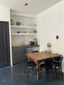 a kitchen with a wooden table and black chairs at Amstel Boutique Studio in Amsterdam +25 photos