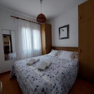 a bedroom with a bed with two towels on it at Apartamentos Xoroi in Cala en Porter