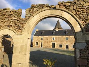 un arco che conduce a un castello con un edificio sullo sfondo di Dépendance de charme totalement rénovée a Saint-Cast-le-Guildo Altre 2 foto