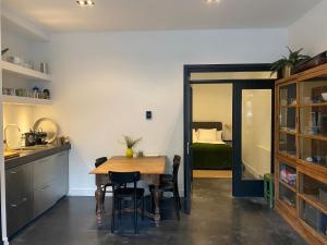 Amstel Boutique Studio في أمستردام: مطبخ مع طاولة وكراسي وغرفة نوم