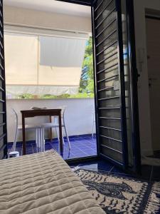 een slaapkamer met een bed, een tafel en een raam bij A un passo dal mare - Costa Ripagnola in Spiaggia di Conversano