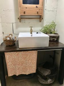 a bathroom sink on a table with baskets on it at Travelers House おーさんてぃん青空舎 in Taketomi