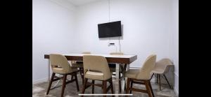 a dining room table with chairs and a tv at 7 bedrooms in Santurce San Juan beach in San Juan