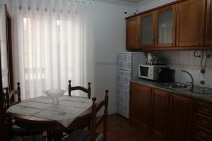 een kleine keuken met een tafel en een magnetron bij Solar do Diabrete in Nazaré