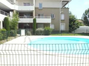 a swimming pool with a tennis net in front of a building at Tout confort ! Calme, Climatisation, Piscine, Parking Gratuit, Grande Terrasse, Netflix, Wifi in Carcassonne