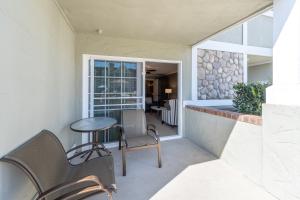 a balcony with a table and chairs and a window at Carlsbad Inn Beach Resort in Carlsbad