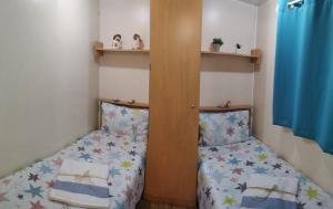 a small room with two beds and shelves at Lodge Rabasquinha in Fronteira