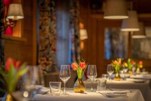 una mesa con copas de vino y flores. en Pension Hinterleithner, en Persenbeug