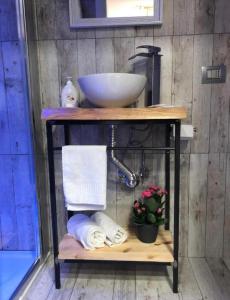 a bathroom with a sink and towels on a shelf at B&B Rial in Naples